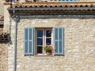 Fototapeta na wymiar Blue window with a vase of flowers in Saint Paul de Vence, France