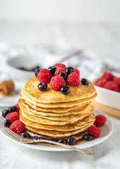 Sweet homemade pancakes with fruits on white plate.