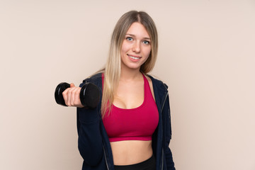 Young sport blonde woman over isolated background making weightlifting