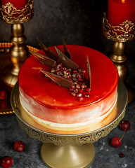 red glazed cake with pomegranate and caramel triangles