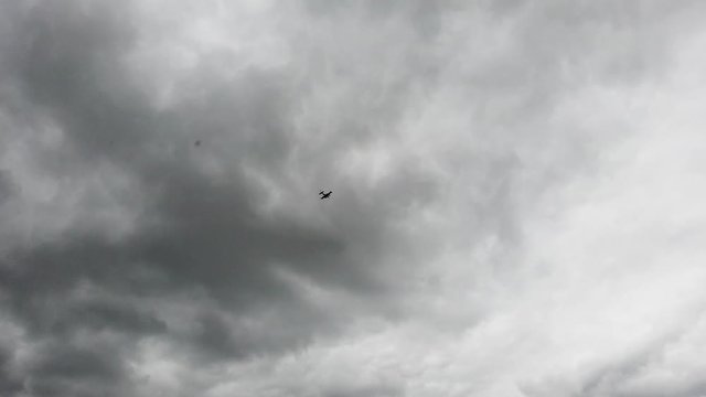 Small two engine plane flying low over a river on a cloudy day