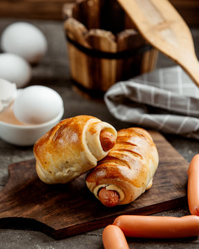 sausage bun rolls served on wooden cutting board