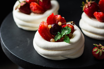 Meringue dessert Pavlova cake with fresh berries on plate. Summer dessert. French cake. Confectionery. Classic dessert. Strawberry dessert.