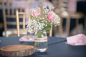 Romantic pink roses and babies breath flowers table centerpiece in glass mason jar with lace decoration - obrazy, fototapety, plakaty