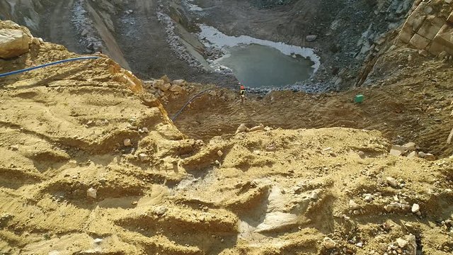 Aerial video footage of a surveyor performing measurements at a quarry