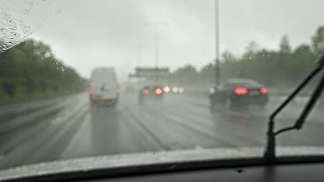 View From Inside Car Driving Along Motorway In Rain With Wipers On Windshield