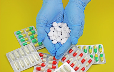a pile of white pill tablet medicine or supplement in women hands