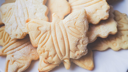 White plate with  gluten-free rice cookies in the shape of a butterfly