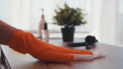 Slow motion hands man sanitizing apartment wiping a table surface with antiseptic spray clean home from dangerous stay at home infection coronavirus COVID-19