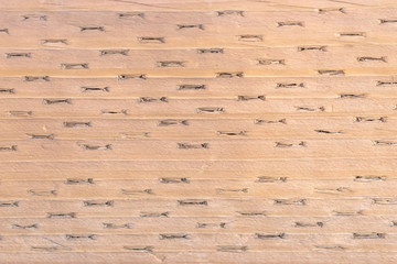 Abstract brown red textured background with horizontal lines and indentations.