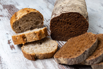 Top view of fresh healthy sliced multi-grain seedy and rye bread on rustic wooden table. Assorted homemade bread, loaves close-up. Baking and home bread making concept, idea, background