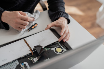 A man disassembles a laptop. Removes the keyboard. Computer service and repair concept. Laptop disassembling in repair shop, close-up. Electronic development, technology fixing