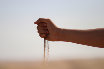 A traveler girl play with sands in the desert
