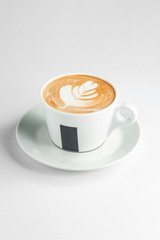 a cup of latte with latte art in white background