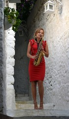 Girl with a saxophone.A blonde girl in a red dress with a saxophone.