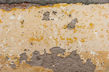 Orange decorative background. In the photo there is a wall with peeling paint and plaster parts. I really need a repair.