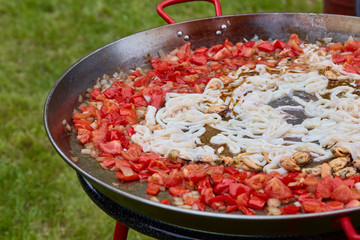 Paella traditional Spanish food. Mussels, squids and tomatoes in the in traditional fry pan
