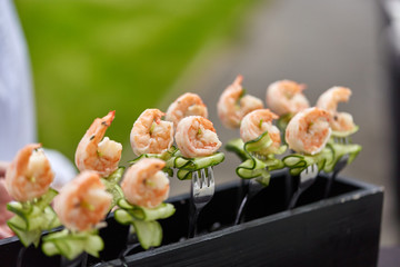 King prawn and cucumber on a fork. Appetizers