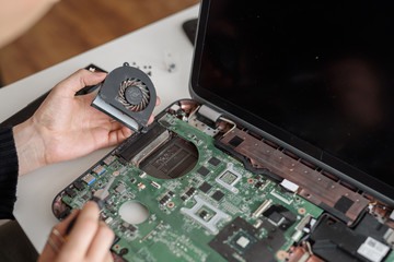 Fixing laptop. Disassembling a notebook and cleaning its cooling system. Dust and dirt on computer fan