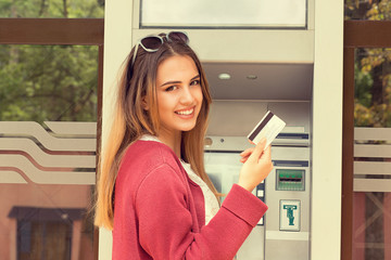 Happy Woman Holding Credit Card near ATM