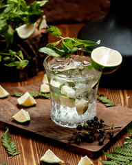 a crystal glass of mojito drink garnished with lime slices