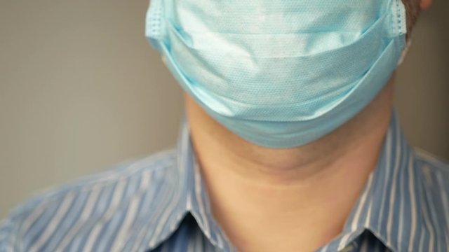 a sad man with virus, covid-19 and mask on his face for antivirus protection taking deep breath, rapid breathing