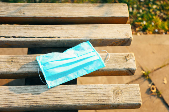 Protective face mask on wooden bench.