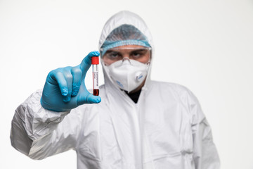 Fototapeta na wymiar Laboratory technician man hand hold on positive blood sample tube for corona virus test , COVID-19. Scientist with blue gloves and mask for protection. Vaccine research for the 2019-nCoV
