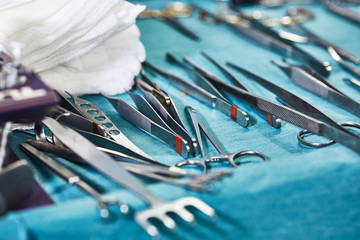 Surgical instruments in the operating room, laid out on a sterile table on a special blue tissue. The concept of medecine, surgery, sterile area. Plastic surgery. Selective focus.