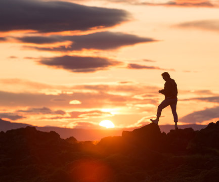 silhouette of a man on a rock at sunset, iceland © Luke