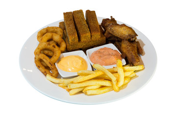 A large portion of fried beer snacks on a white plate. crackers with garlic, onion rings in batter, fried chicken wings and French fries with two types of sauces. on white background