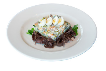 Olivier salad with meat and quail eggs on a white plate. on white background