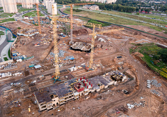 Aerial view of construction site of residential area buildings with cranes