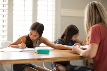 Mother Helping Her Daughters With Their Homework
