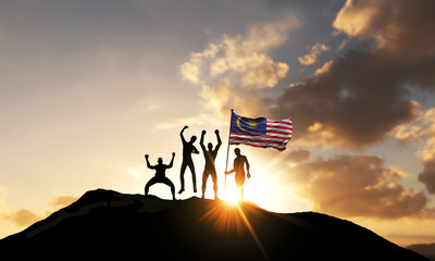 A group of people celebrate on a mountain top with malaysia flag. 3D Render