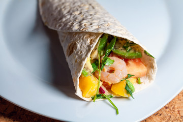 Pita with shrimp salad with avocado, onion, pepper, tomato, parsley and pine nuts in pitta bread. Mexican burrito. Shaorma. Tortilla