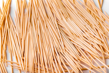 A large group of pointed, sharp toothpicks made of wood close-up. Texture, pattern, and background of toothpicks.
