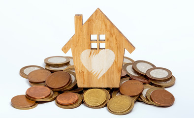 A pile of coins and a wooden house