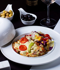 a plate of chicken dish covered with melted cheese served with lettuce salad