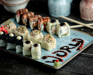 a platter of sushi rolls with salmon black tobiko tempura