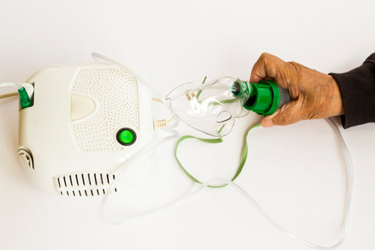 Home type mini air machine with oxygen mask on white holding hand of older person.