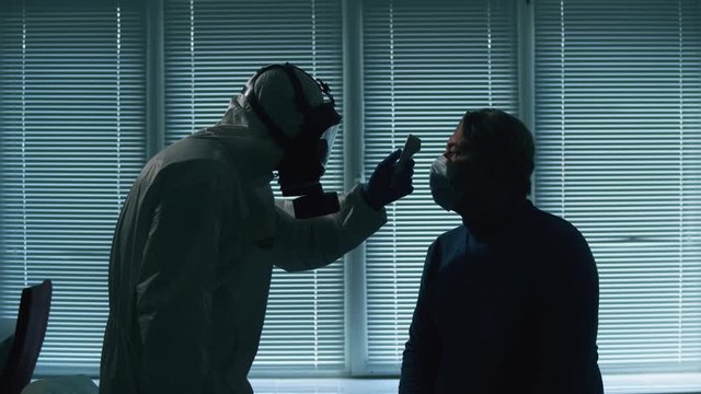 Male patient is getting his temperature measured by a doctor