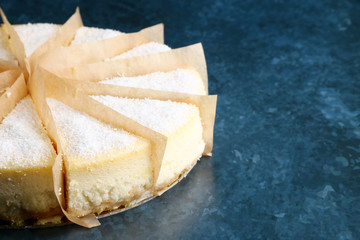 delicious cheesecake with coconut closeup on blue marble background. cheesecake portion cutting dessert closeup