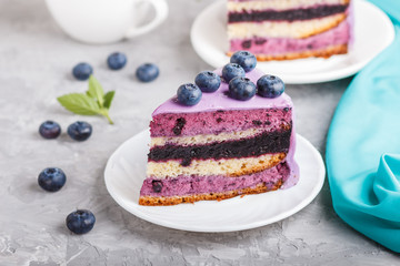 Homemade cake with souffle cream and blueberry jam with cup of coffee on a gray concrete  background. side view.