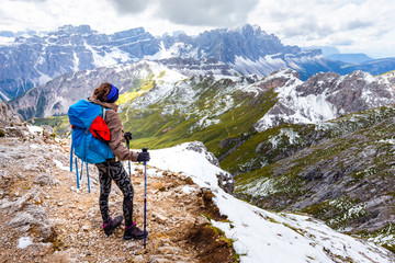 Backpacker female tourist standing alone mountain cliff ridge edge landscape.
