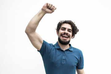 Happy excited guy making winner gesture, enjoying success. Handsome bearded young man in blue...