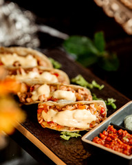 close up of mini tacos served with chili paste