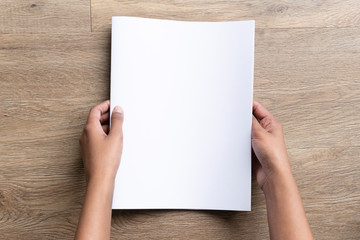 Woman of color holding a blank half letter-sized or A5 mockup.