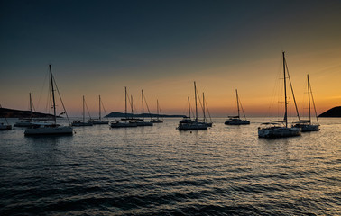 Fototapeta premium Parking of sailboats at marina in Croatia at sunset, The picturesque horizon, islands on a background, orange color