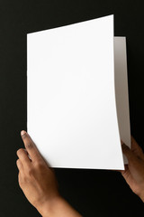 Woman of color holding a blank letter-sized or A4 mockup.